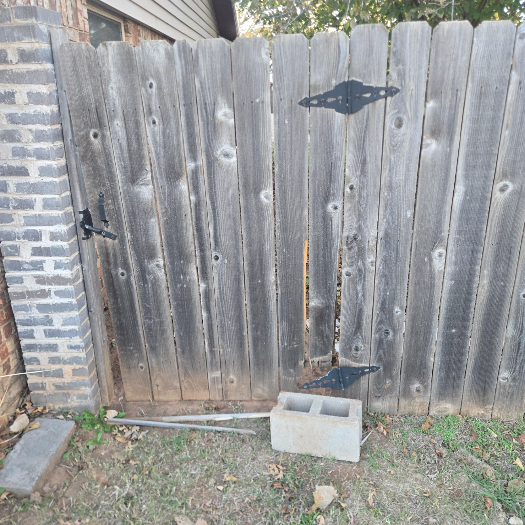 Fence gate repair with weathered wooden panels in Stillwater, OK