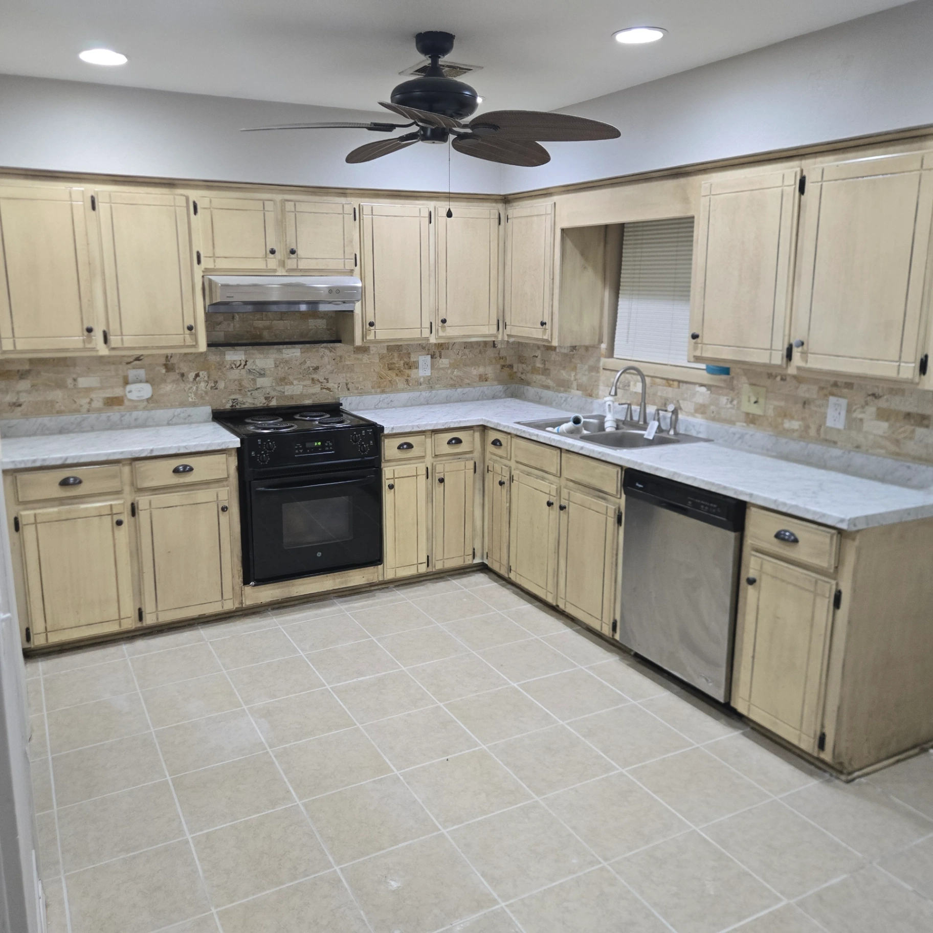 Completed kitchen renovation with new cabinets, backsplash, and tile flooring in Stillwater, OK